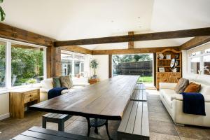 - une grande table en bois dans le salon avec canapés dans l'établissement Bramley Barn near Bath + Hot tub, à Siston