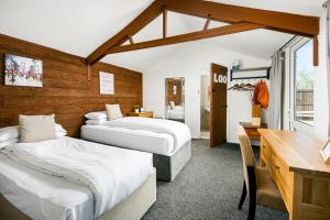 a hotel room with two beds and a desk and a desk at Bramley Barn near Bath + Hot tub in Siston