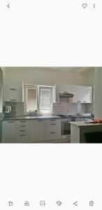 a kitchen with white cabinets and white appliances at Apartments Golić in Biograd na Moru