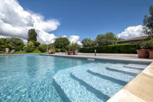 une grande piscine d'eau bleue dans l'établissement ClickSardegna Villa Lavinia con piscina e accesso alla laguna Calich, à Casa Linari