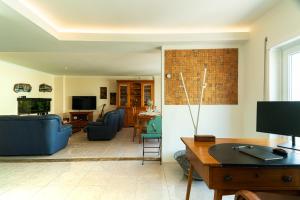 a living room with blue couches and a tv at Family Comfort House in Seixal