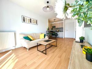 uma sala de estar com um sofá e uma mesa em Lanester - Le Parc à bois - Wifi Fibre - Balcon - Parking privé em Lanester