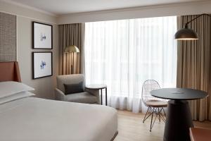 a hotel room with a bed and a chair and a table at Sheraton Gateway Hotel in Toronto International Airport in Mississauga