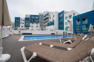 una piscina con tumbonas y una piscina en Bay View Modern Apartment, en Albufeira