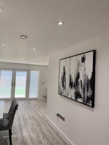 a living room with a chair and a painting on the wall at G2 Luxury Rooms in a Shared House in Basildon