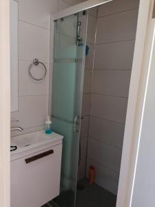 a bathroom with a glass shower and a sink at Villa suzi in Aydın