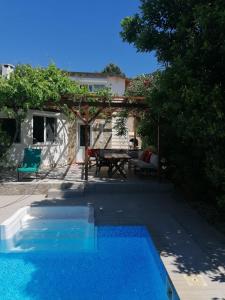 a swimming pool in front of a house with a picnic table at Villa suzi in Aydın