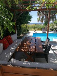 una mesa y sillas bajo una pérgola junto a una piscina en Villa suzi, en Aydın