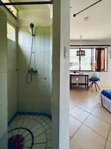 a bathroom with a shower and a table in a room at CASA MOSAICO in Puerto López