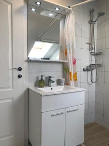 uma casa de banho branca com um lavatório e um espelho em Villa Fragola 2 em Doli