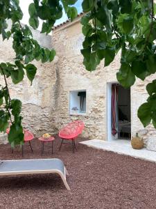 two red chairs and a table in front of a building at La Santa in Almagro