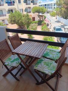 a wooden table and two chairs on a balcony at Formenterasuite 16 in Es Pujols