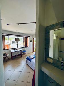 a bedroom with a bed and a bathroom with a table at CASA MOSAICO in Puerto López