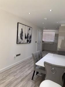a dining room with a white table and chairs at G2 Luxury Rooms in a Shared House in Basildon
