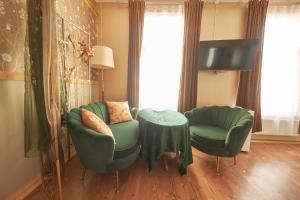a living room with two chairs and a table and a tv at Amalie Apartment in Haapsalu