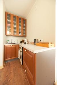 a kitchen with wooden cabinets and a white counter top at Amalie Apartment in Haapsalu