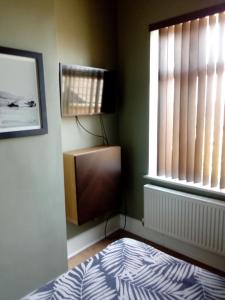 a bedroom with a bed and a window at DERBY in Derby