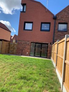 a brick house with a fence in a yard at G2 Luxury Rooms in a Shared House in Basildon