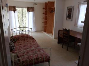 a bedroom with a bed and a desk and a window at Casa en Río Ceballos. Muy buena ubicación. in Río Ceballos