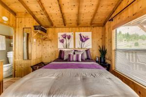 1 dormitorio con 1 cama en una habitación de madera en Mayhill Tiny Home Vacation Rental with Covered Porch en Mayhill