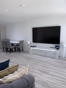 a living room with a large flat screen tv at G2 Luxury Rooms in a Shared House in Basildon