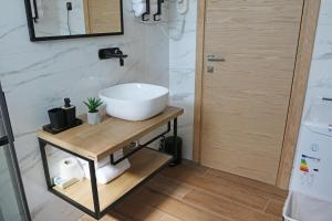 een badkamer met een witte wastafel op een houten tafel bij Avangard HOME I 