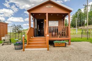 a small wooden cabin with a porch and stairs at Tiny Home with Covered Porch in Cloudcroft Area! in Mayhill