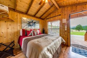 a bedroom with a large bed in a wooden room at Tiny Home with Covered Porch in Cloudcroft Area! in Mayhill