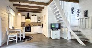 a kitchen with a staircase and a table and a television at Żółte Drzwi Sucha Rzeczka in Sucha Rzeczka