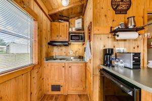 a kitchen with wooden cabinets and a counter top at Tiny Home with Covered Porch in Cloudcroft Area! in Mayhill