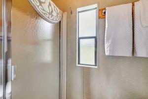 a bathroom with a shower door and a window at Tiny Home with Covered Porch in Cloudcroft Area! in Mayhill