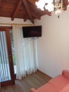 uma sala de estar com uma televisão de ecrã plano na parede em Casa de Santa Luzia A em Vila Praia de Âncora