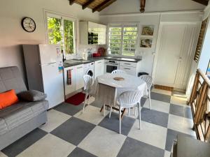una cucina con tavolo, sedie e frigorifero di Ti bijou a Baie-Mahault