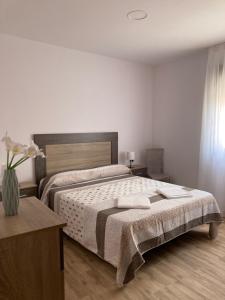 sypialnia z dużym łóżkiem i drewnianą podłogą w obiekcie La Quesería w mieście Villaherreros
