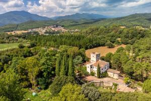 an aerial view of a house with trees and mountains at La Torre de Vilanna in Bescanó