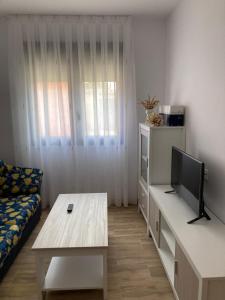 a living room with a couch and a tv and a table at La Quesería in Villaherreros