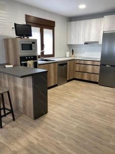 a kitchen with stainless steel appliances and wooden cabinets at La Quesería in Villaherreros