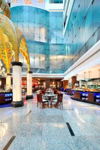 a restaurant with a table and chairs in a building at Le Meridien Coimbatore in Coimbatore