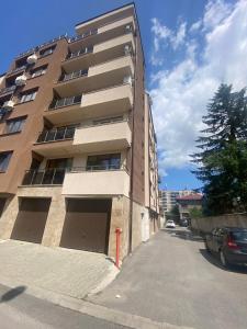 a tallartment building with a parking lot next to it at Sunny Spacious Apartment in a Great Location in Kazanlŭk