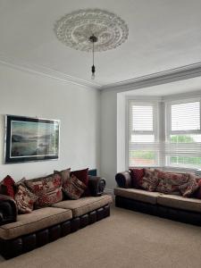 a living room with two couches and two windows at Spacious 4 Bed Property - Sleeps 8 in Gateshead in Felling