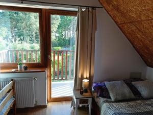 ein Schlafzimmer mit einem Bett und einem großen Fenster in der Unterkunft Solorena in Junoszyno