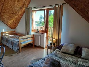 a bedroom with a bed and a window with a balcony at Solorena in Junoszyno