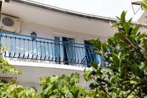 un balcón azul en un edificio blanco con ventana en Apartments Vila Nikolić Rafailovići, en Rafailovici