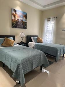 a bedroom with two beds and a painting on the wall at Casa Bella Vista @ Pyramid Point in Ocho Rios +18 photos
