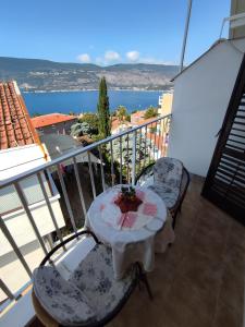 un tavolo e sedie su un balcone con vista sull'oceano di Smestaj Vella a Herceg-Novi