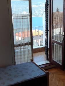 Zimmer mit einem Fenster und Blick auf einen Balkon. in der Unterkunft Smestaj Vella in Herceg-Novi