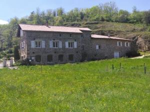 una gran casa de piedra en un campo de hierba en Domaine de Minodier - Gite 6 pers. (Chez Maryline), en Ardoix