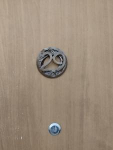 uma maçaneta de porta com dois anéis numa porta de madeira em פטל em Bersebá