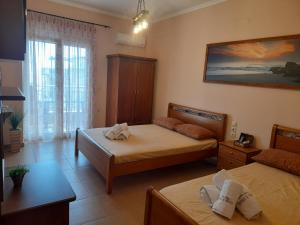 - une chambre avec 2 lits et une fenêtre dans l'établissement tomas & maria rooms, à Neoi Poroi