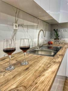 two glasses of wine sitting on a counter in a kitchen at Coastline of paradise 2 in Paránimfoi